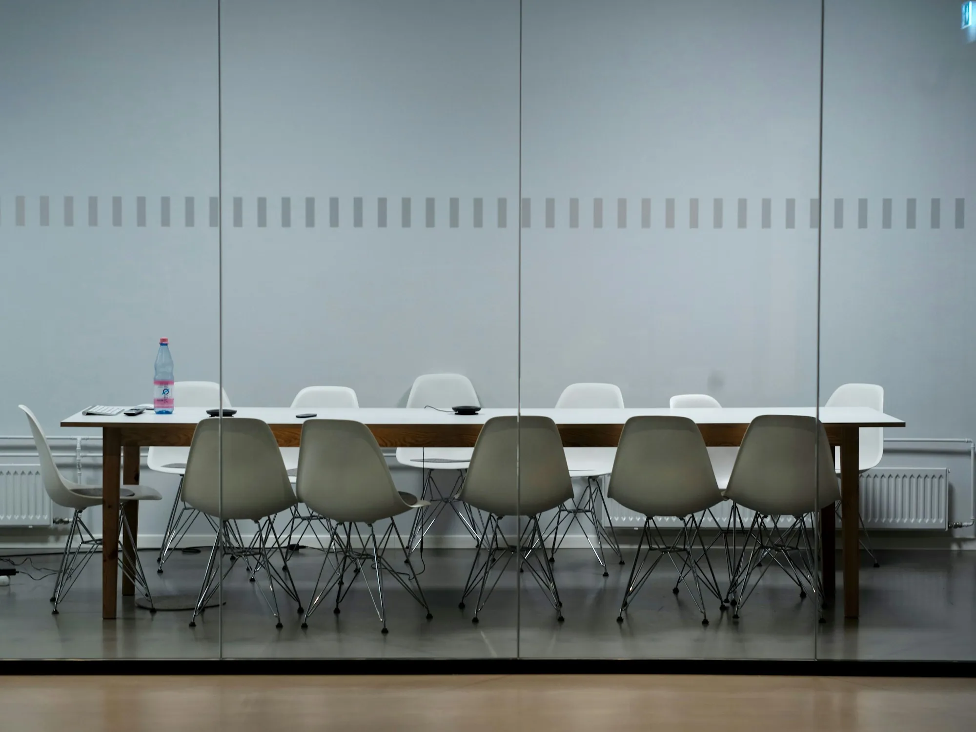 Glass-walled meeting room with a long table
