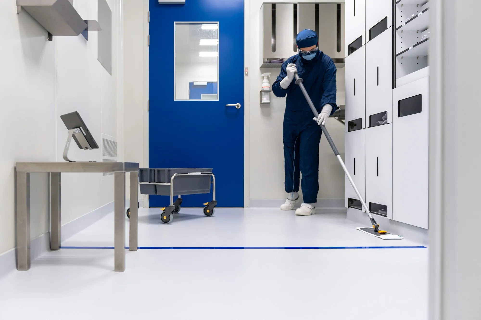 Cleaner mopping a hallway floor in a clean facility